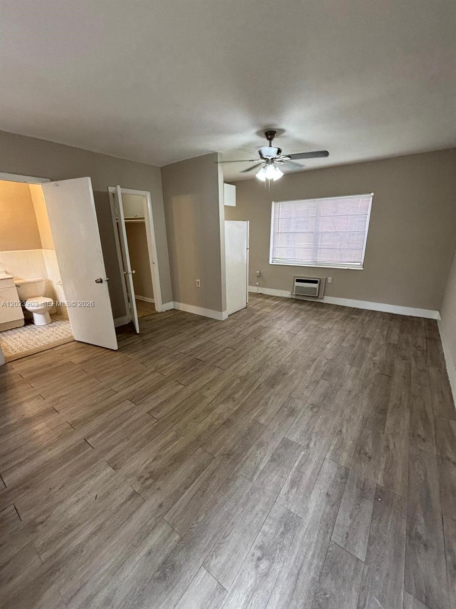 520 Southwest 4th Street, Unit 11 Miami, FL 33130 - Photo 2 of 7 an empty room with wooden floor ceiling fan and windows