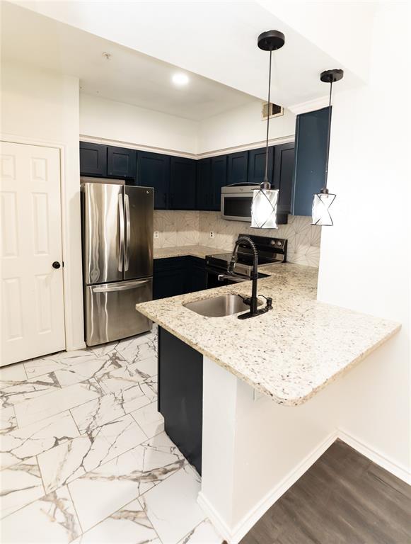 2601 Preston Road, Unit 7203 Plano, TX 75093 - Photo 11 of 27 a kitchen with stainless steel appliances kitchen island a refrigerator sink and microwave