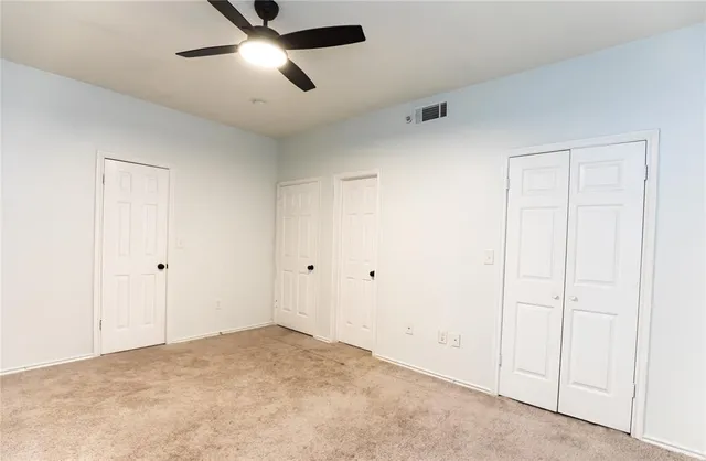 a view of a hallway with wooden floor and a bathroom