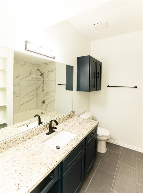 2601 Preston Road, Unit 7203 Plano, TX 75093 - Photo 23 of 27 a bathroom with a granite countertop sink a toilet and mirror