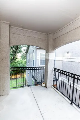a view of a porch with wooden floor and iron fence