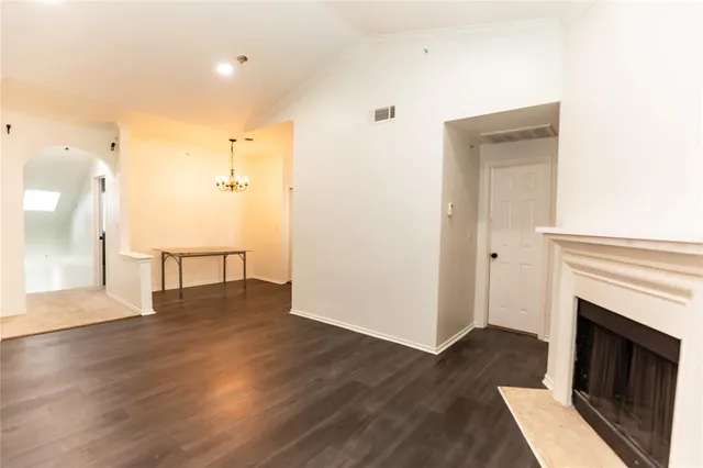 a view of a livingroom with wooden floor and a kitchen