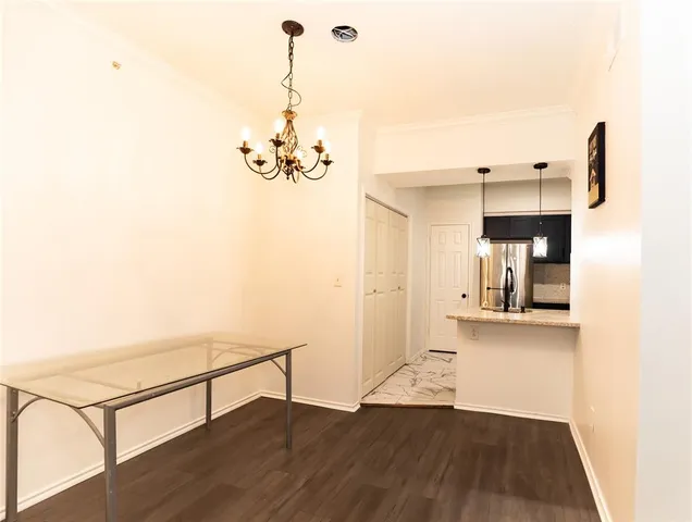 a view of an empty room with wooden floor and a fireplace