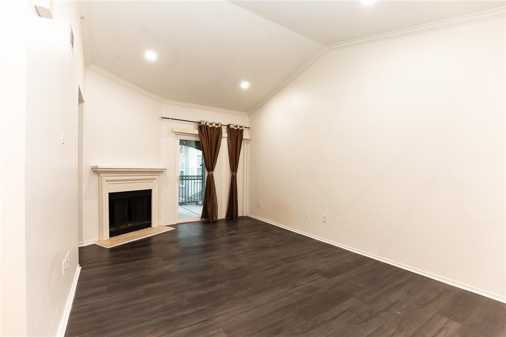 2601 Preston Road, Unit 7203 Plano, TX 75093 - Photo 8 of 27 a view of an empty room with wooden floor and a fireplace