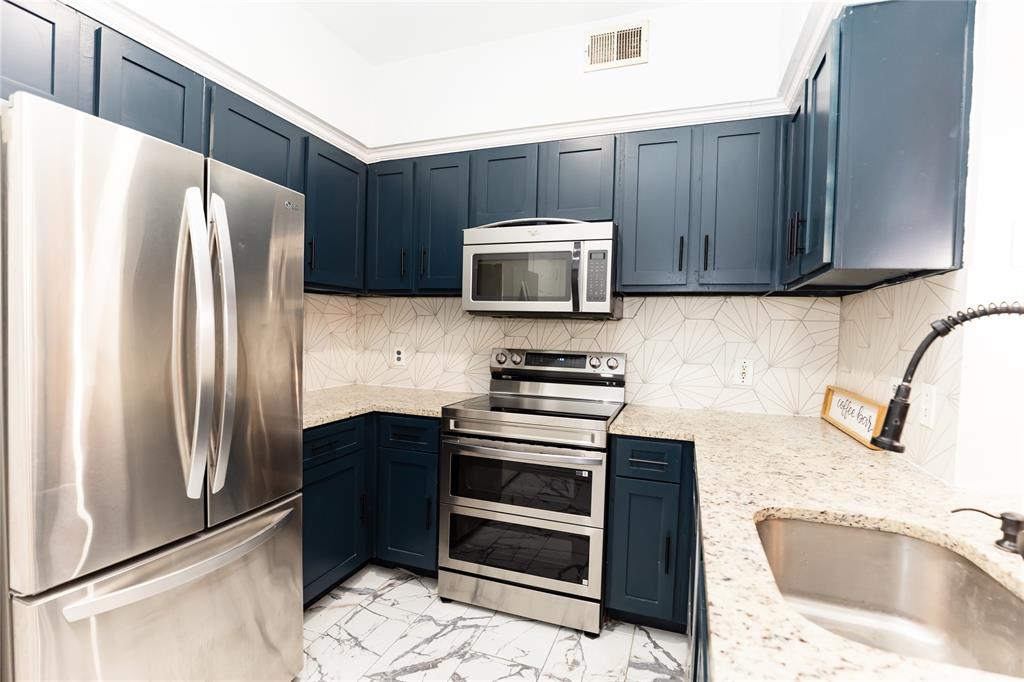 2601 Preston Road, Unit 7203 Plano, TX 75093 - Photo 10 of 27 a kitchen with granite countertop a refrigerator and a sink