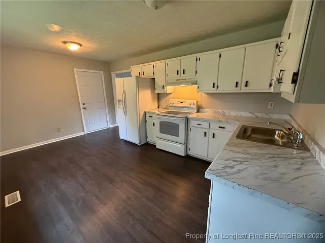 a kitchen with sink a stove and cabinets