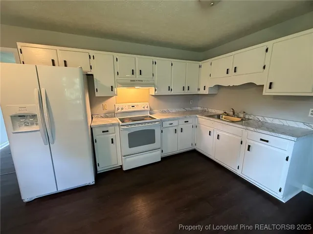 a kitchen with cabinets oven a sink and dishwasher