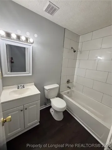 a bathroom with a toilet a sink a mirror and bathtub