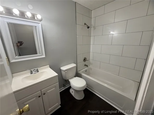 a bathroom with a sink a toilet a mirror and shower