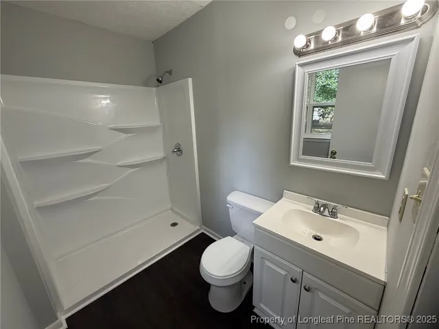 a bathroom with a sink a toilet and shower