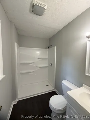a bathroom with a toilet and a shower