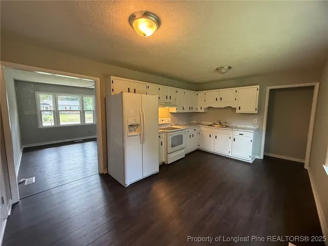 a kitchen with stainless steel appliances a sink cabinets and wooden floor