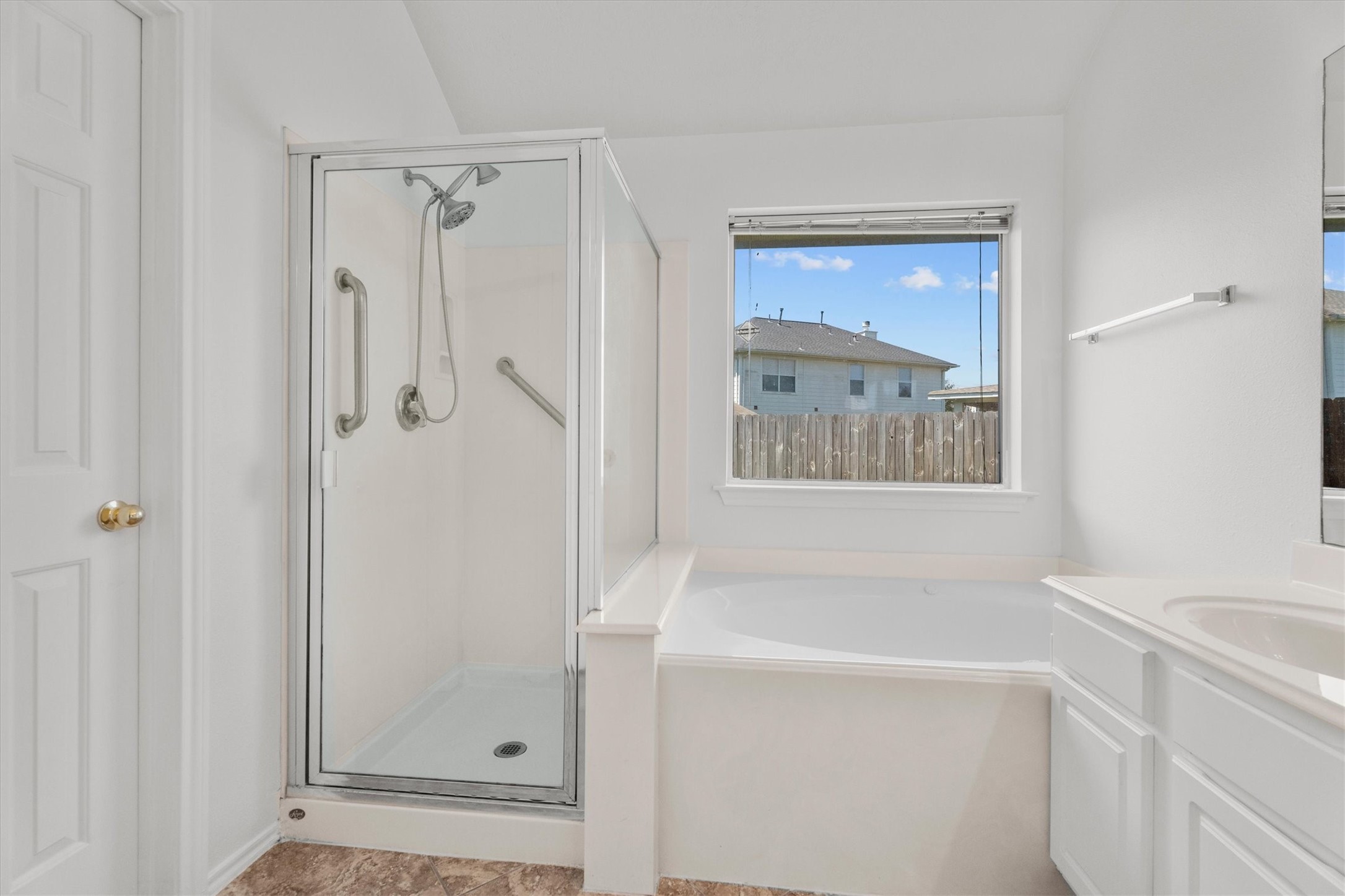 2507 Grayfeather Court Spring, TX 77388 - Photo 18 of 37 Primary bathroom featuring a modern walk-in shower with glass doors, a spacious soaking tub beneath a bright window, and a white vanity with storage.