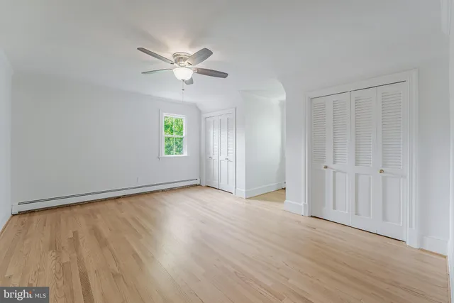 an empty room with windows and fireplace