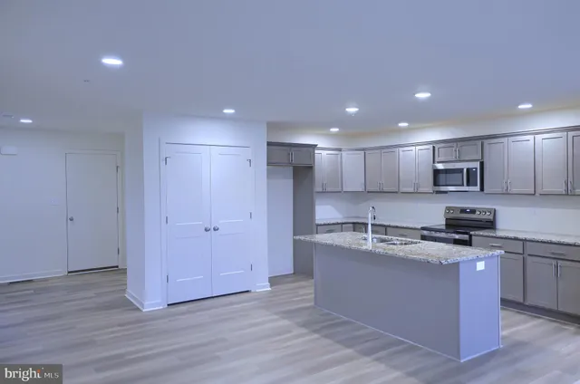 a kitchen with stainless steel appliances granite countertop a sink a stove a refrigerator and cabinets