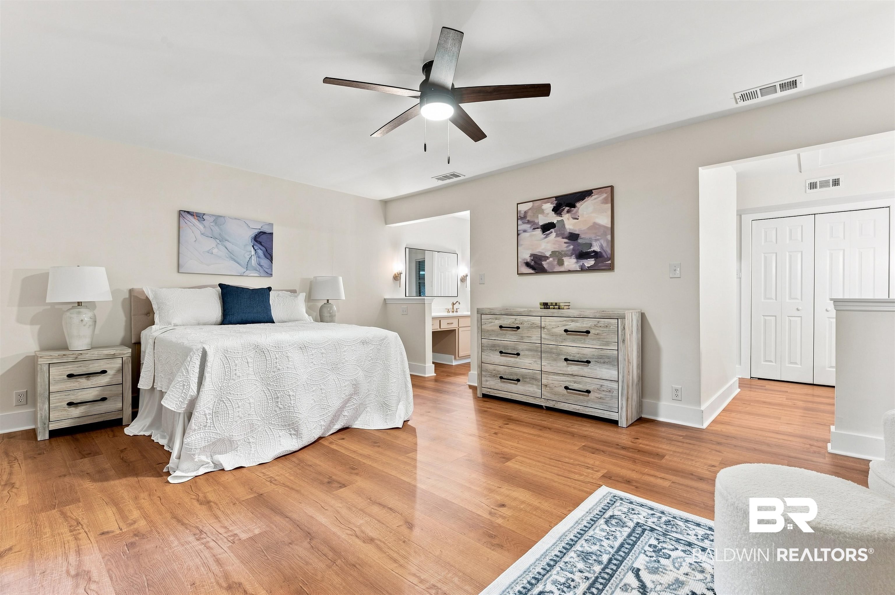 599 Ridgewood Drive Daphne, AL 36526 - Photo 14 of 41 Spacious bedroom featuring wood-finish flooring, a contemporary ceiling fan, and white baseboards