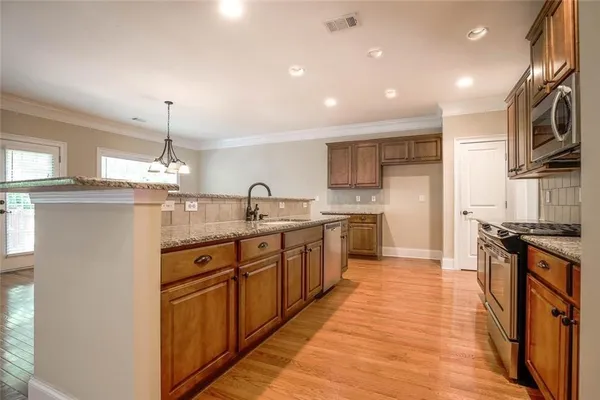 a kitchen with stainless steel appliances granite countertop a sink and stove top oven