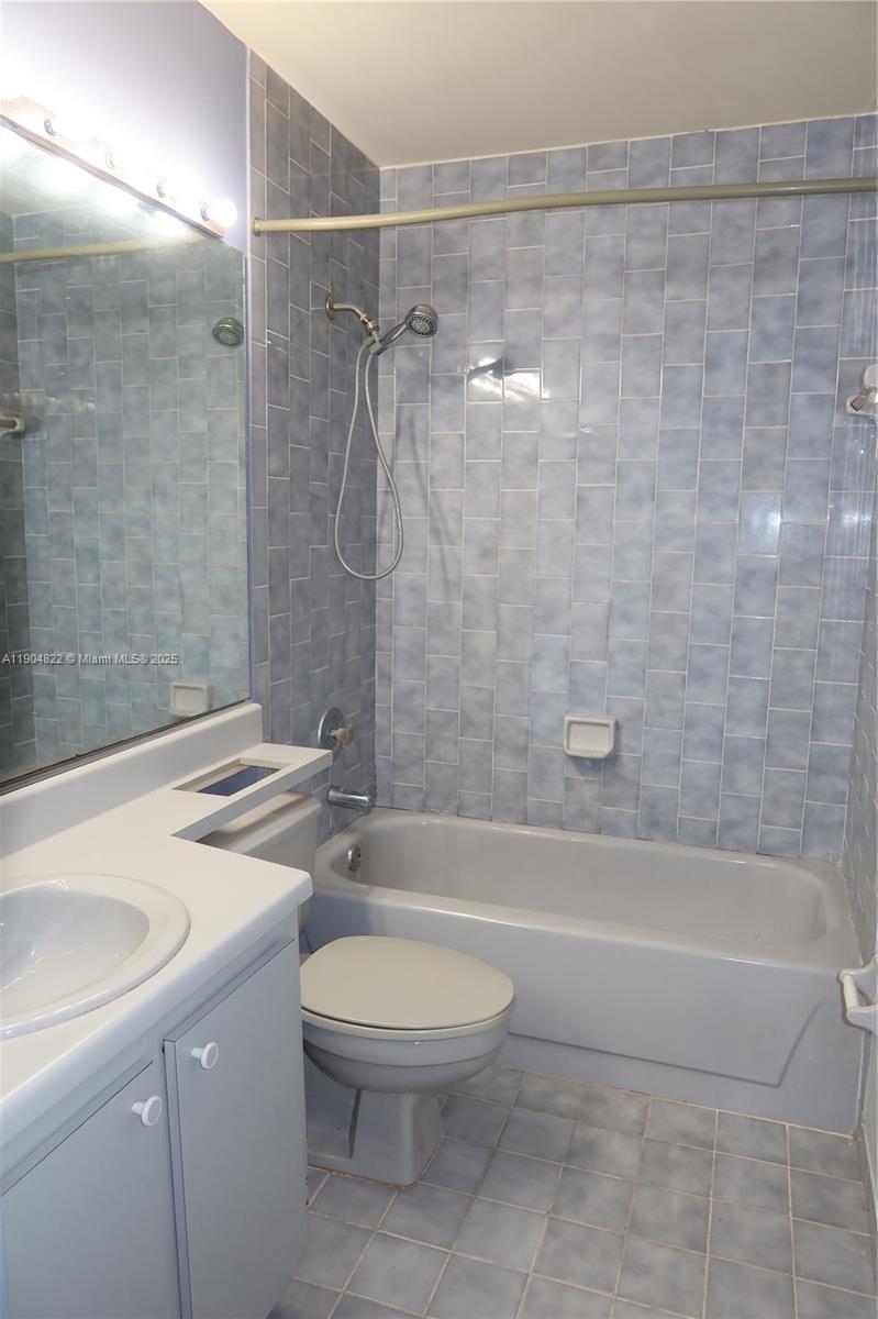 12059 Southwest 10th Street, Unit 201 Miami, FL 33184 - Photo 12 of 17 a bathroom with a granite countertop bathtub shower sink vanity and toilet
