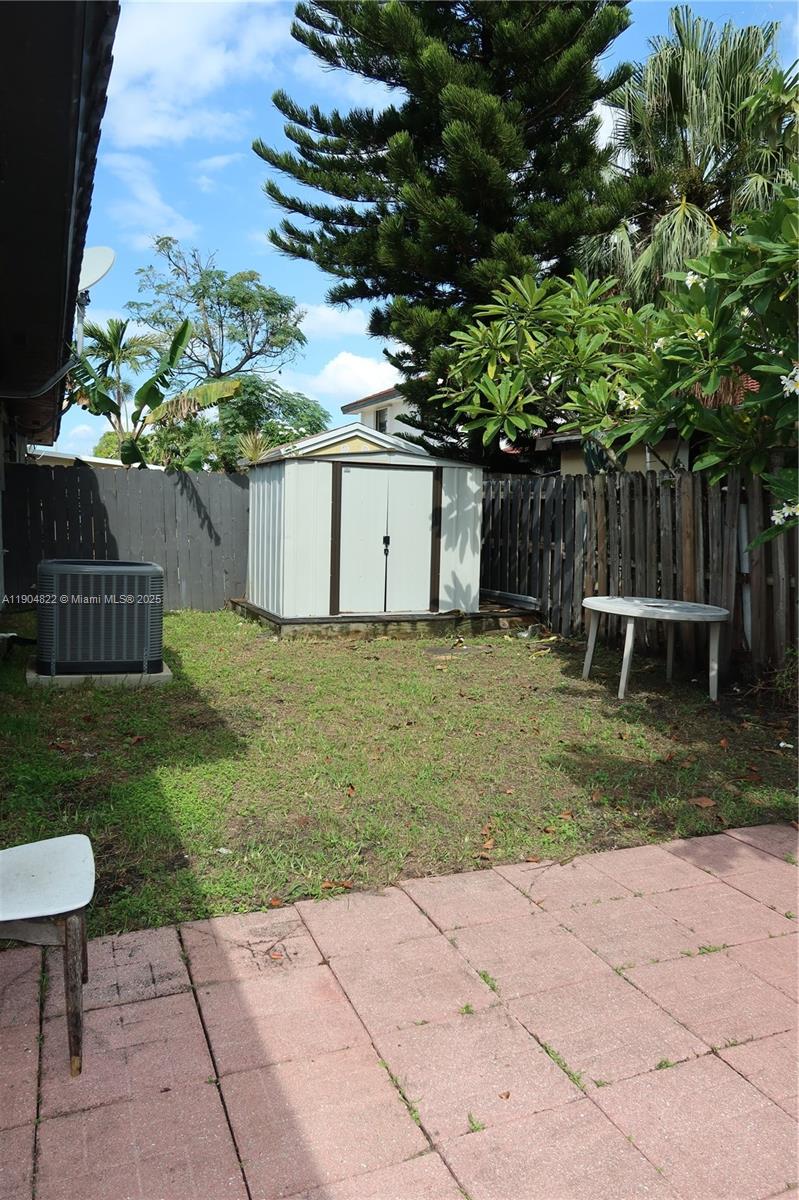 12059 Southwest 10th Street, Unit 201 Miami, FL 33184 - Photo 14 of 17 a backyard of a house with plants and wooden fence