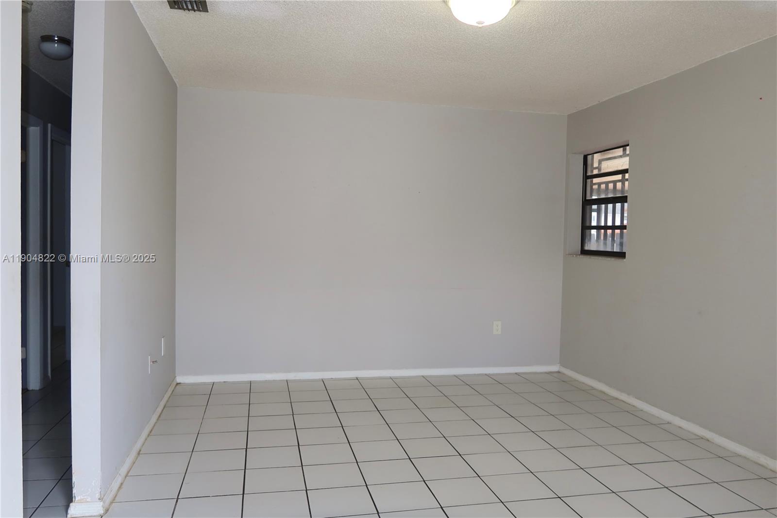 12059 Southwest 10th Street, Unit 201 Miami, FL 33184 - Photo 4 of 17 a view of an empty room and window