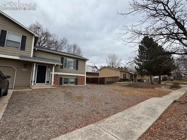 a view of a house with a yard covered in snow