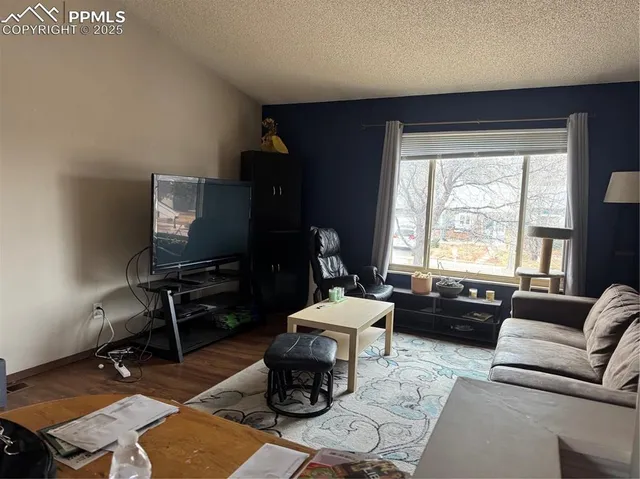 a living room with furniture a window and a flat screen tv