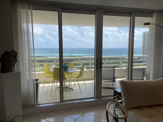 a living room with a floor to ceiling window and an outdoor view