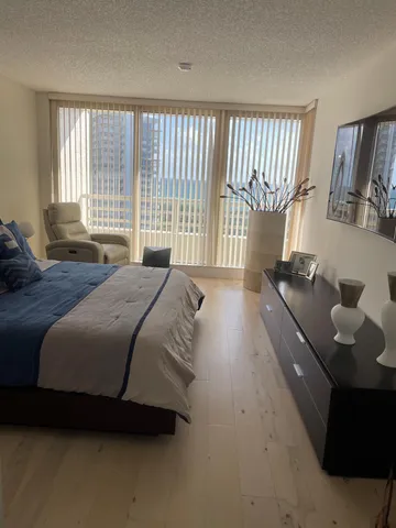 a spacious bedroom with a bed and a large window