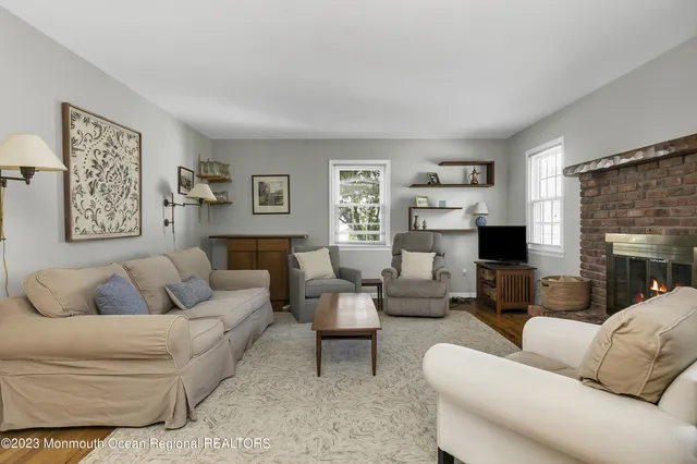 a living room with furniture a fireplace and a large window