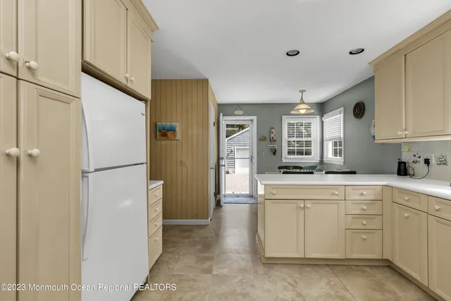 a kitchen with white cabinets and refrigerator