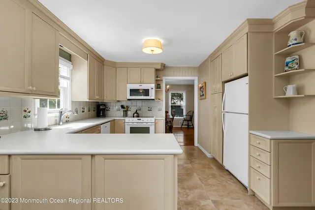 a kitchen with stainless steel appliances granite countertop a refrigerator sink stove microwave and cabinets