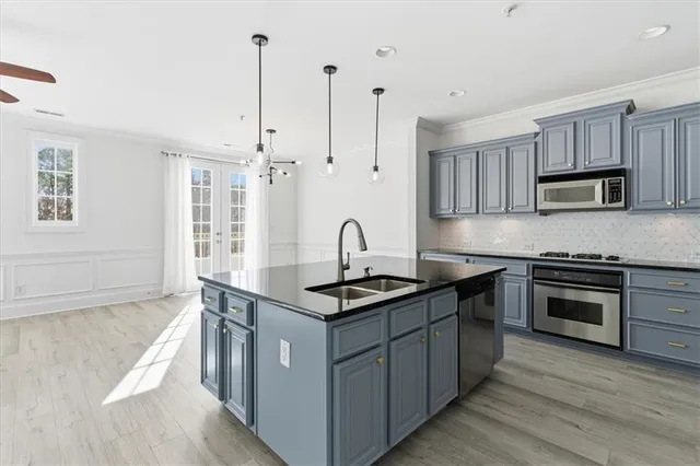 a kitchen with kitchen island granite countertop a sink stove and cabinets