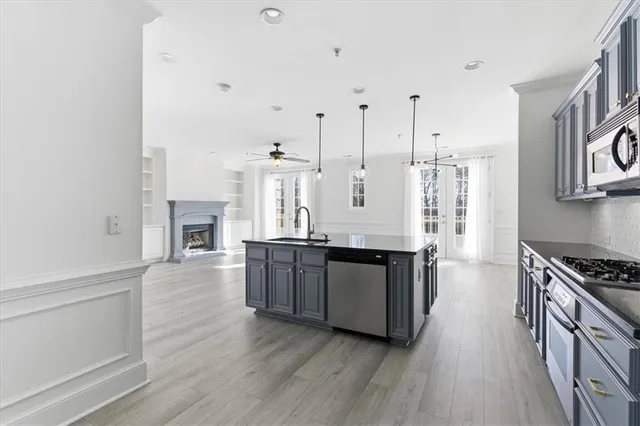 a large kitchen with cabinets wooden floor and stainless steel appliances