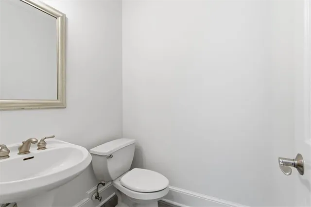 a white toilet sitting next to a white sink
