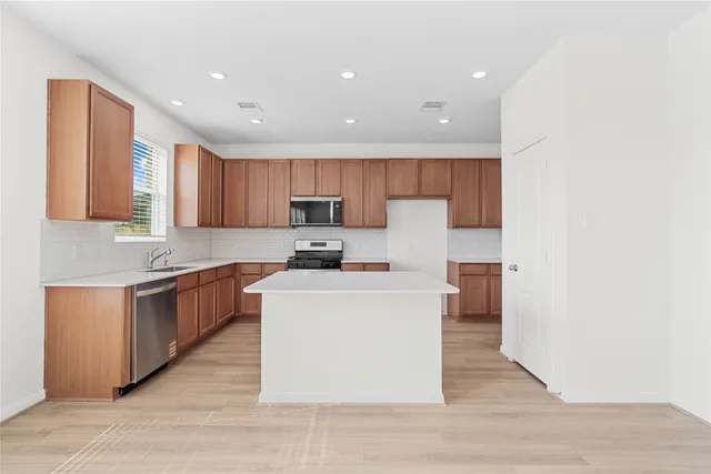 a kitchen with stainless steel appliances sink stove microwave and cabinets