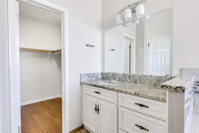 a bathroom with a granite countertop sink and a mirror