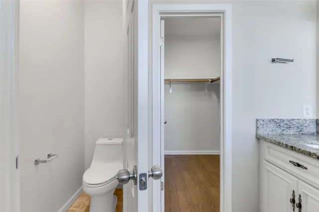 a bathroom with a granite countertop toilet and a sink