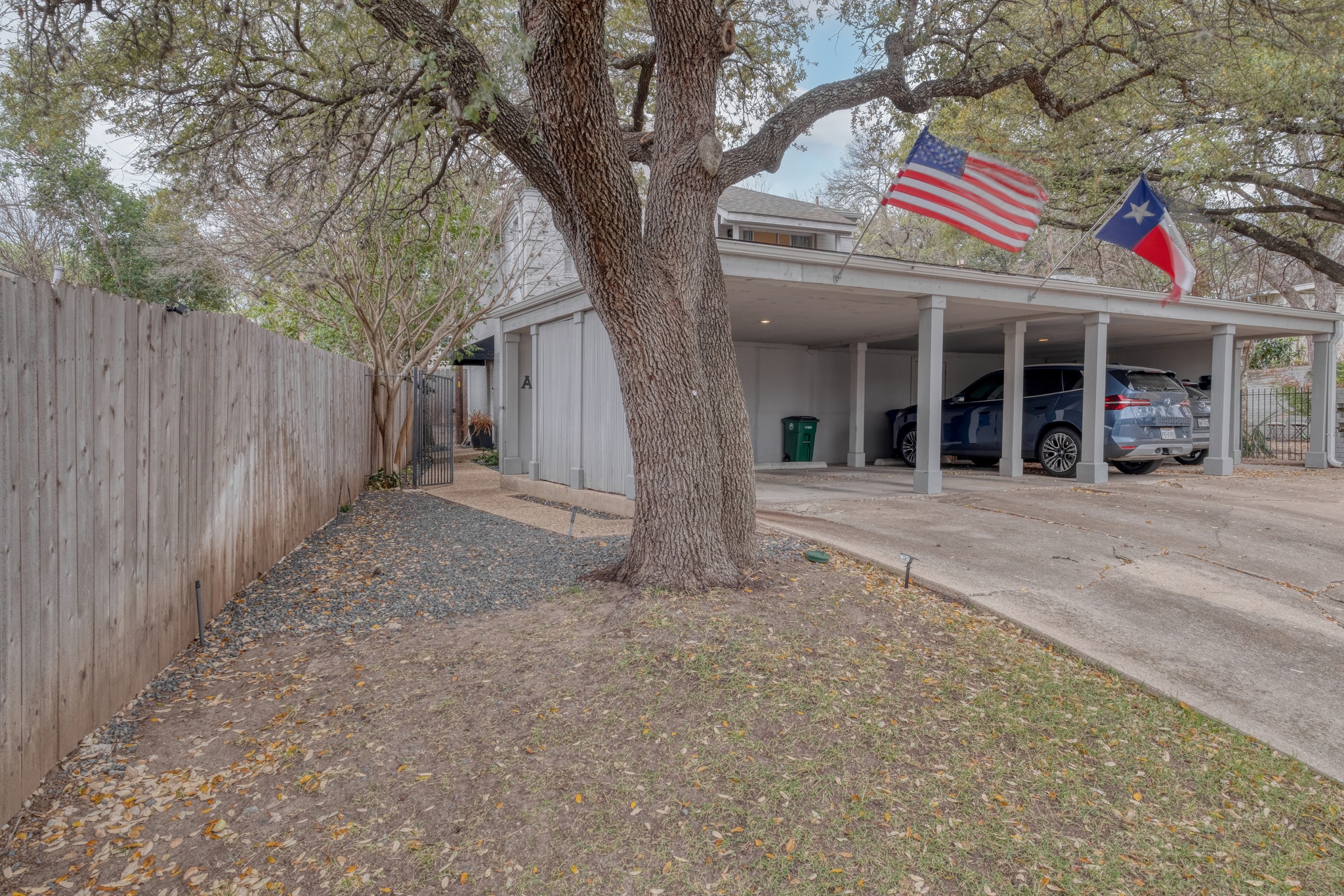 a view of a white house with large windows and a small yard