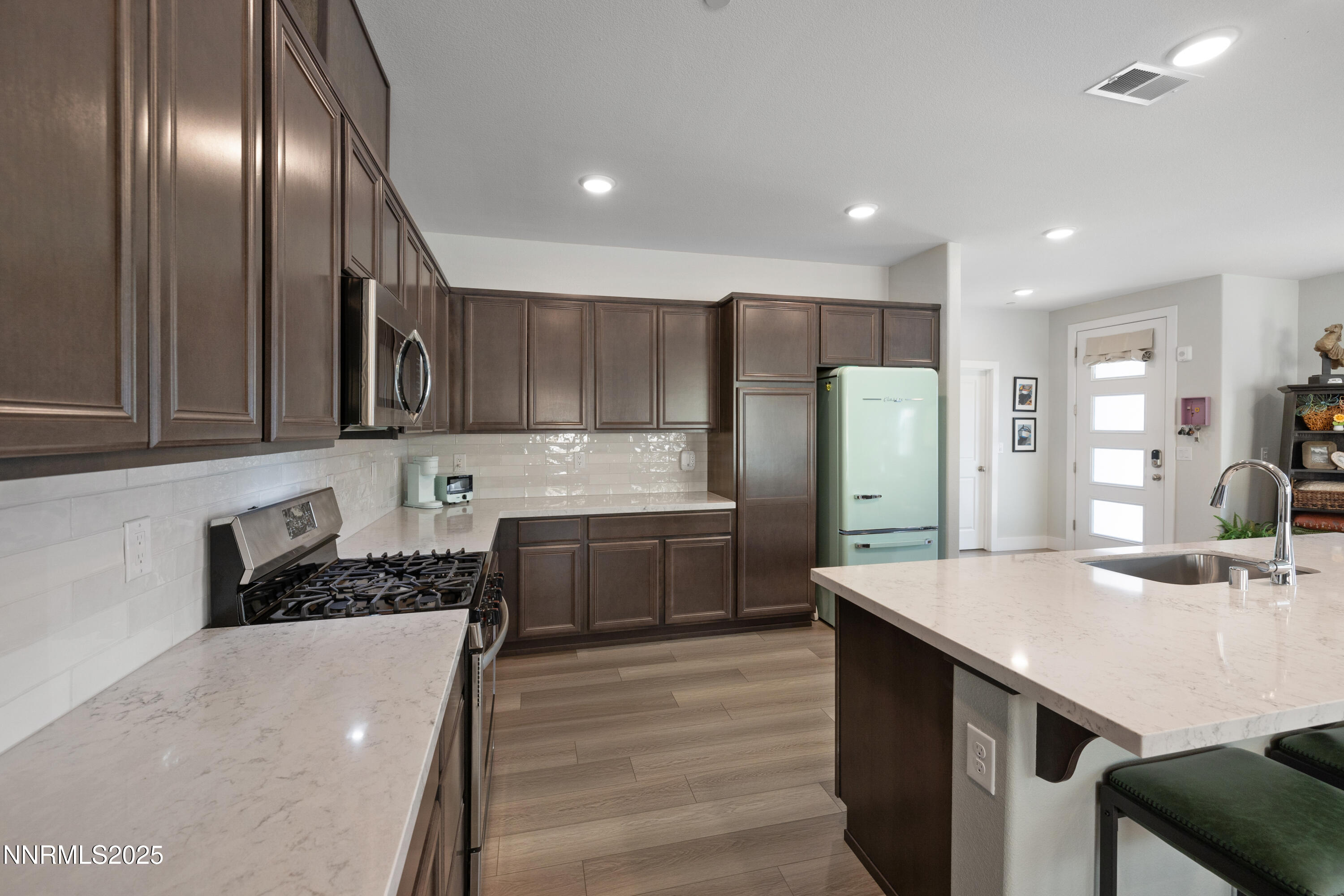 3604 Pulsar Lane, Unit 3 Carson City, NV 89705 - Photo 12 of 59 a kitchen with stainless steel appliances a sink a stove a refrigerator cabinets and chairs