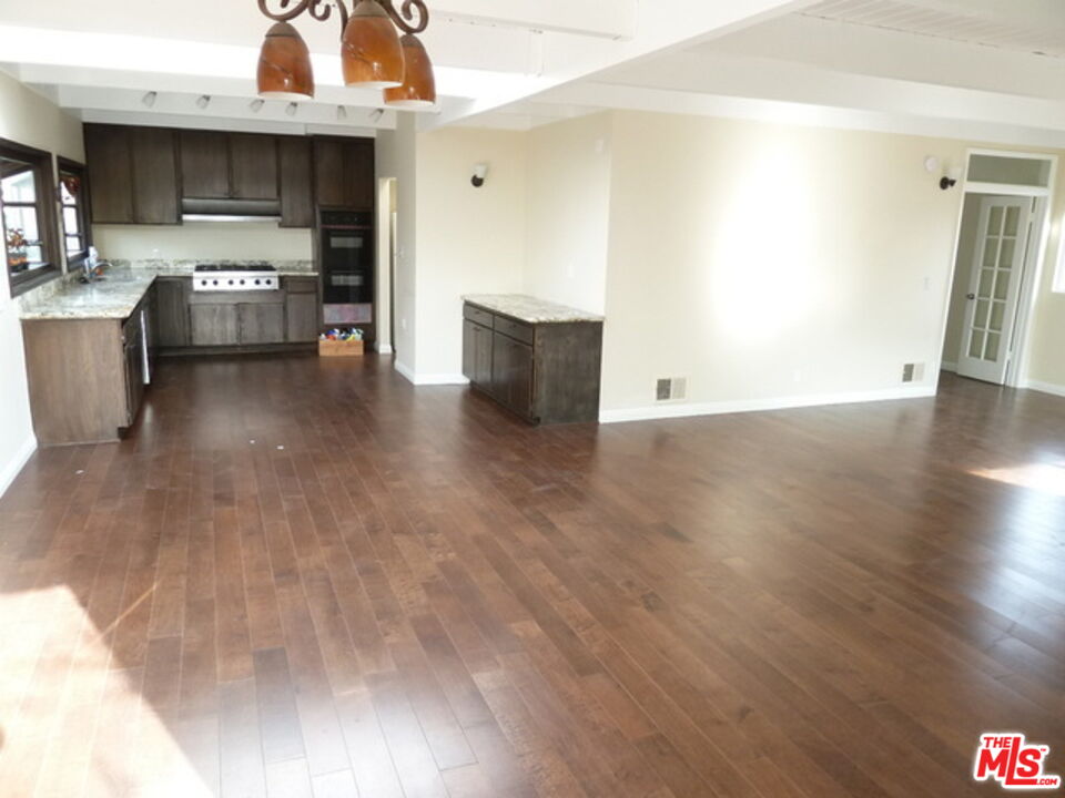 a kitchen with granite countertop a stove and a wooden floors