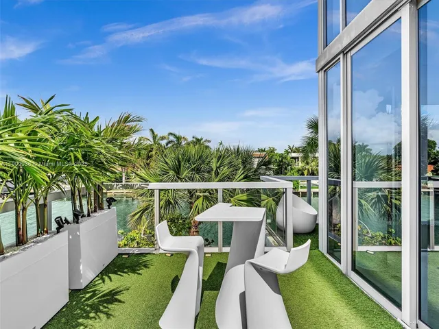 a balcony with couple of potted plants and couches