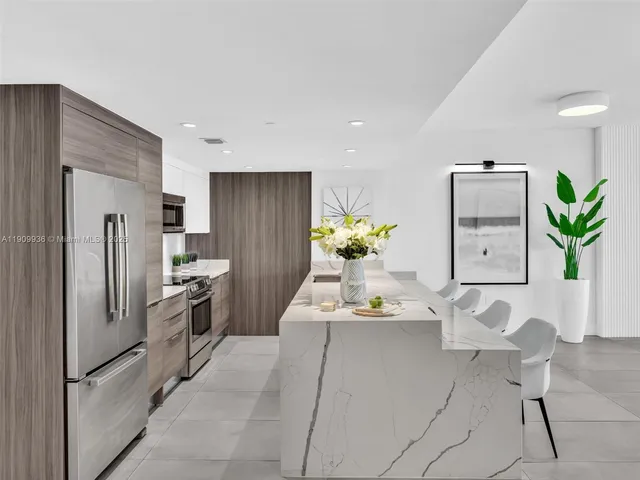 a kitchen with stainless steel appliances a dining table cabinets and wooden floor
