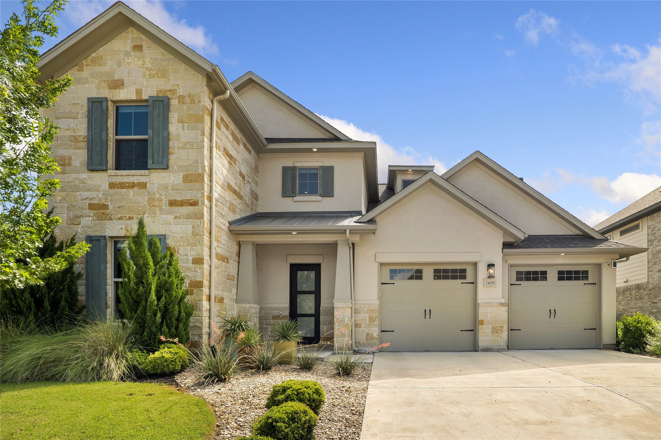 2408 Nate's Place Georgetown, TX 78633 - Photo 39 of 40 A striking contemporary residence featuring a blend of natural stone and stucco, complete with a two-car garage and manicured landscaping.