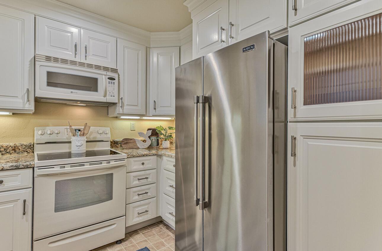 250 Forest Ridge Road, Unit 64 Monterey, CA 93940 - Photo 14 of 35 a kitchen with white cabinets and stainless steel appliances