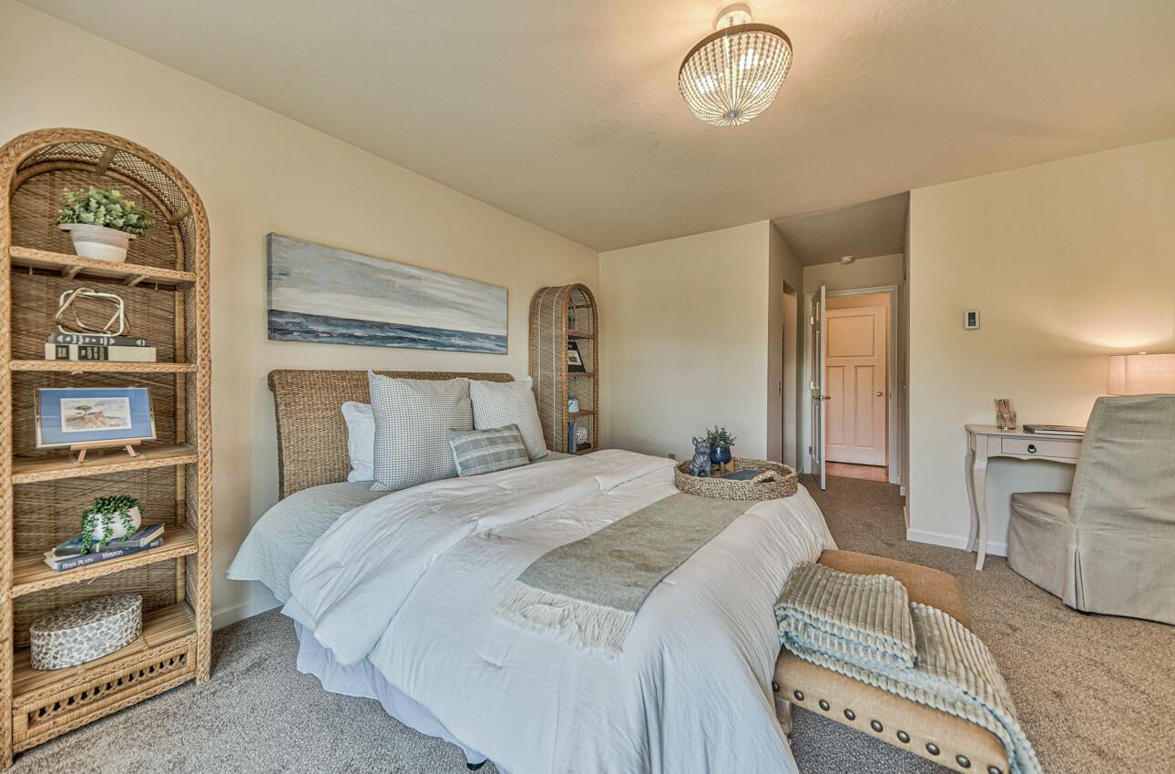 250 Forest Ridge Road, Unit 64 Monterey, CA 93940 - Photo 23 of 35 a bedroom with a bed and a chandelier