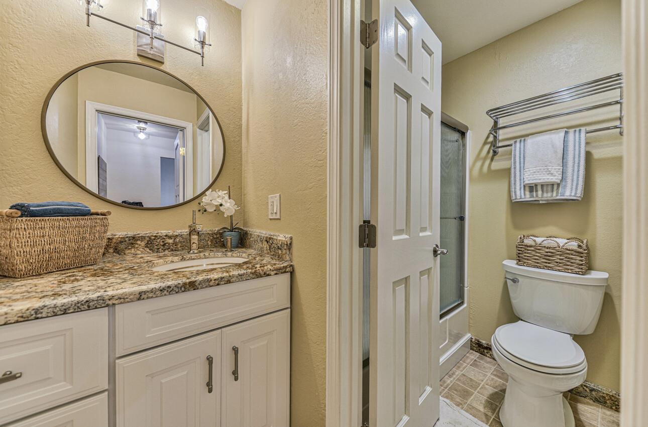 250 Forest Ridge Road, Unit 64 Monterey, CA 93940 - Photo 28 of 35 a bathroom with a granite countertop toilet sink and mirror