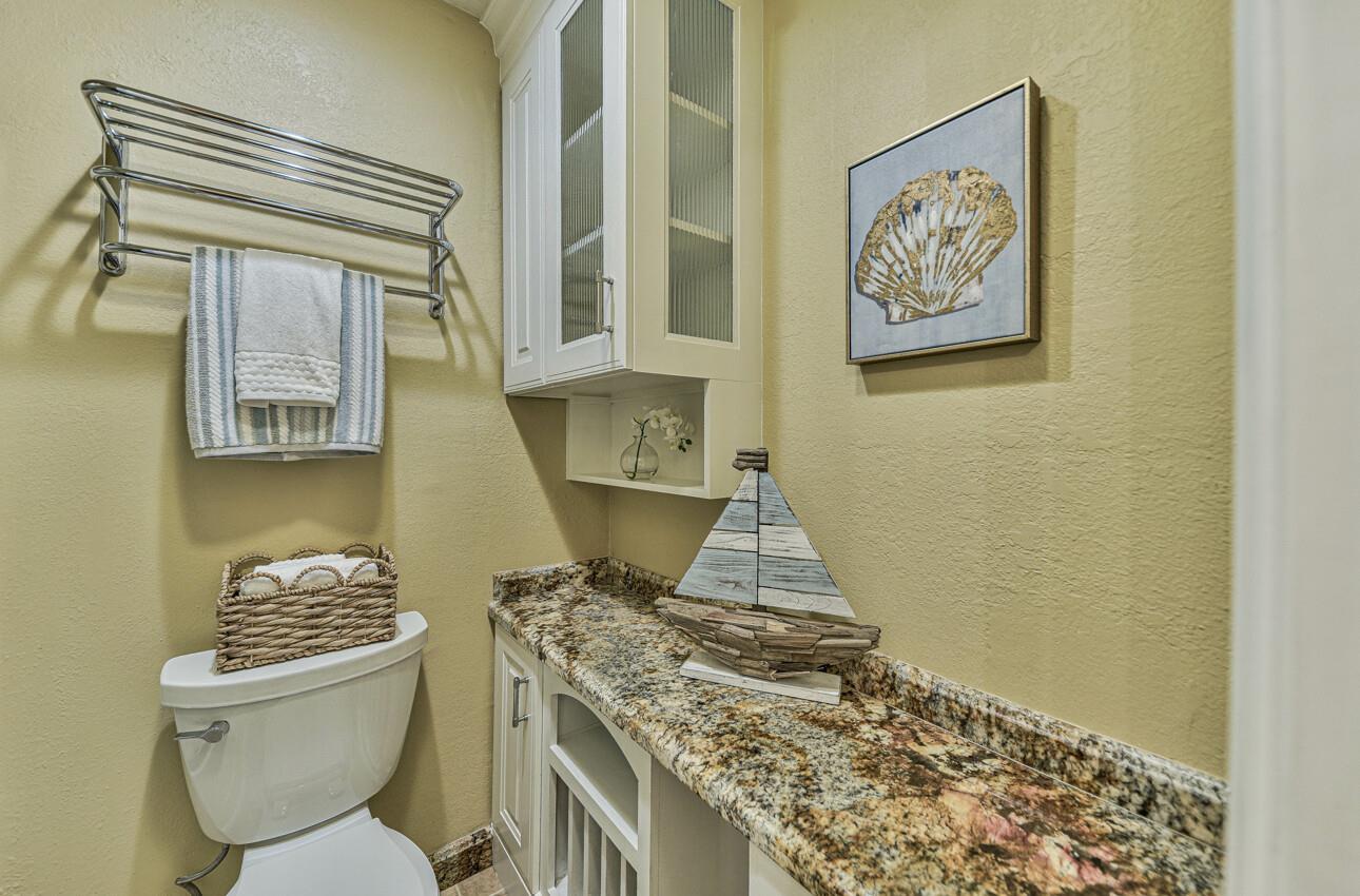 250 Forest Ridge Road, Unit 64 Monterey, CA 93940 - Photo 30 of 35 a bathroom with a granite countertop toilet and a sink