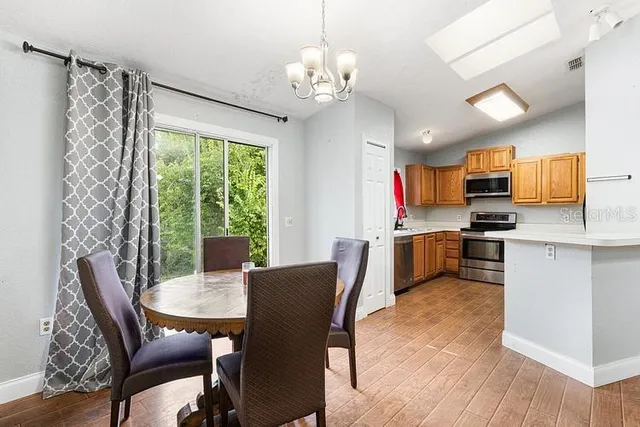 a view of a dining room with furniture a chandelier and wooden floor