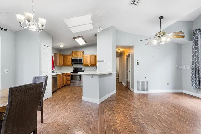 a view of a kitchen with sink microwave and cabinets