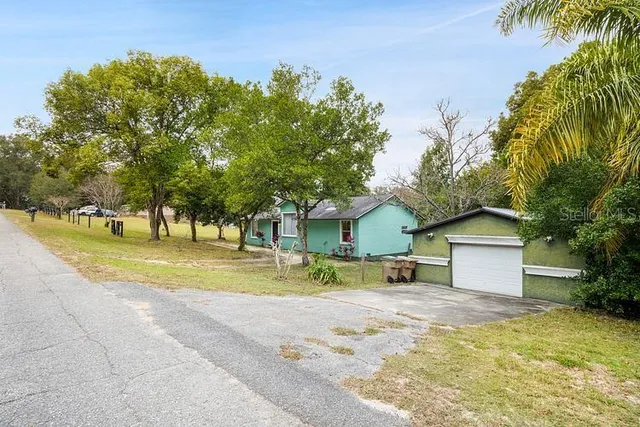 a view of a house with a tree and a yard